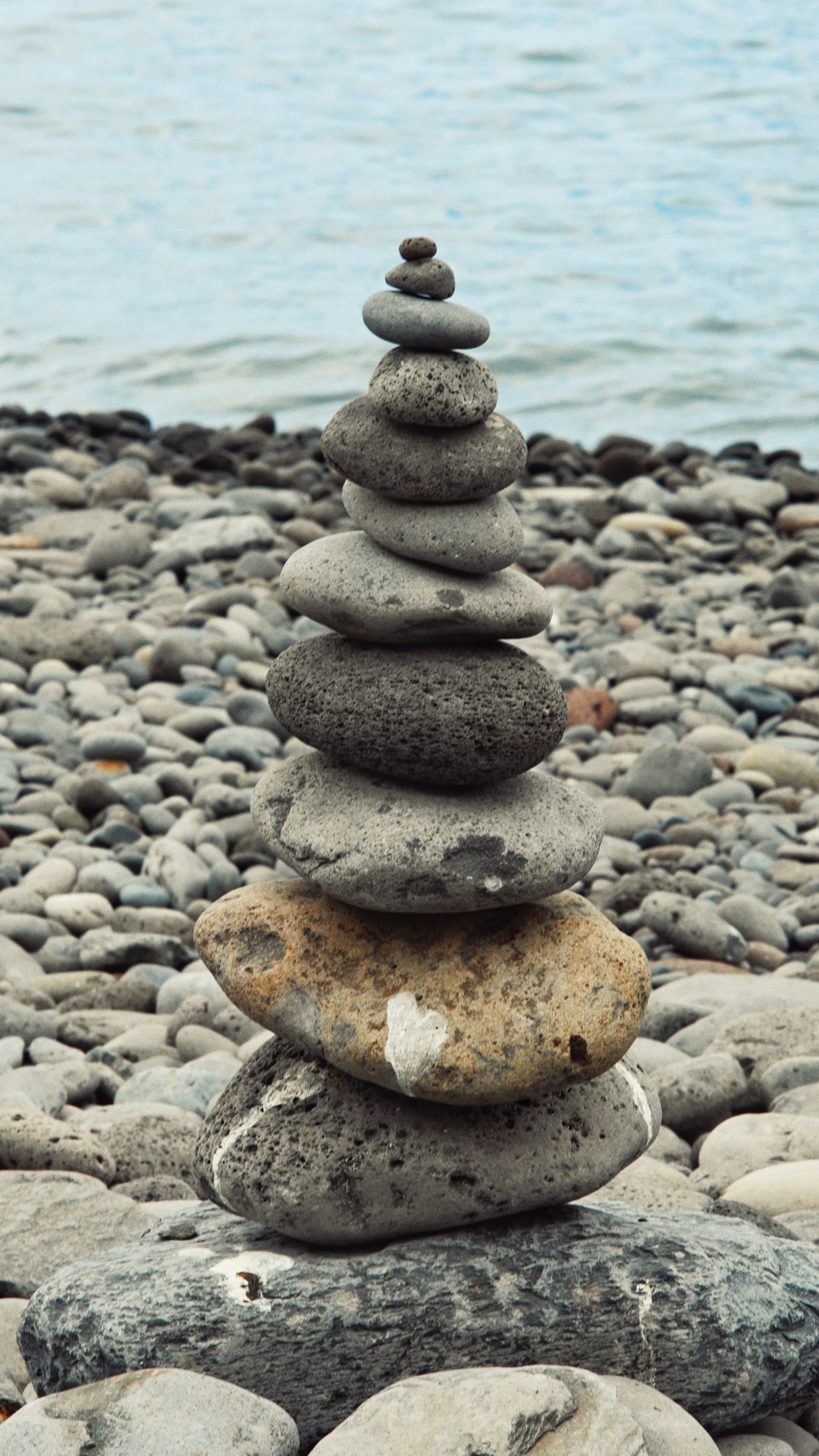 Pedras equilibradas em uma praia rochosa — equilíbrio, leveza e vitalidade
